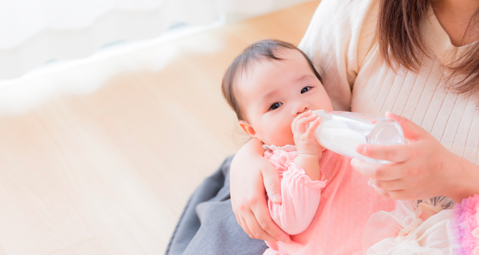 赤ちゃんが哺乳瓶でミルクを飲む画像
