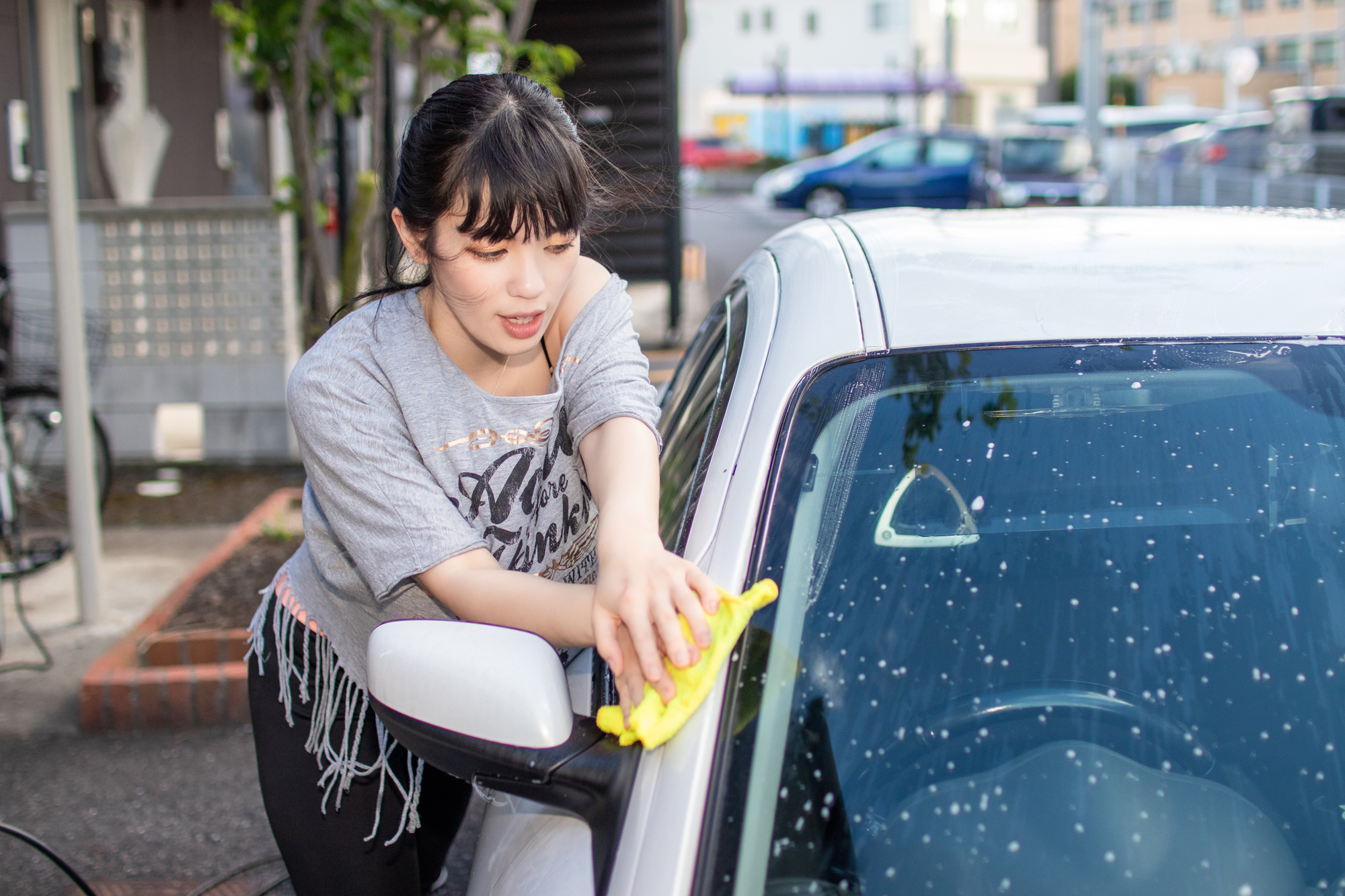 女性が洗車している画像